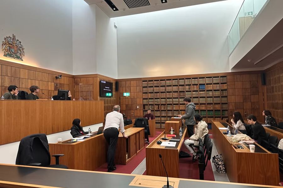 A session held in the courtroom at the University of Hertfordshire, with students seated at the benches